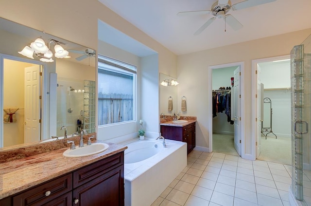 172 Omaha Ave, Clovis, CA 93619 - bathroom featuring a ceiling fan, a shower stall, a bath, tile patterned flooring, and a spacious closet