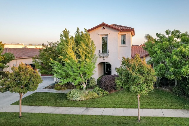 172 Omaha Ave, Clovis, CA 93619 - mediterranean / spanish home featuring a tile roof, a balcony, stucco siding, and a front yard