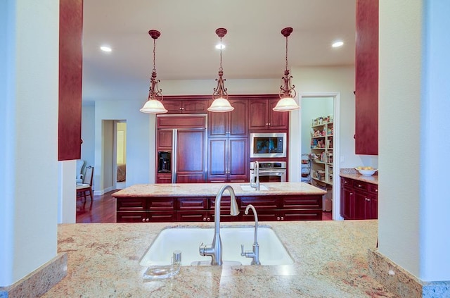 172 Omaha Ave, Clovis, CA 93619 - kitchen featuring built in appliances, a sink, dark brown cabinets, decorative light fixtures, and recessed lighting