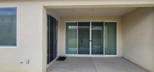doorway to property with a patio and stucco siding