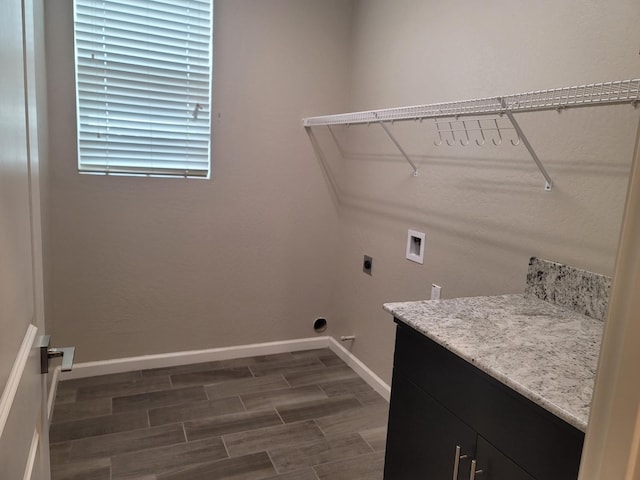 laundry area featuring baseboards, hookup for a washing machine, dark wood finished floors, electric dryer hookup, and cabinet space