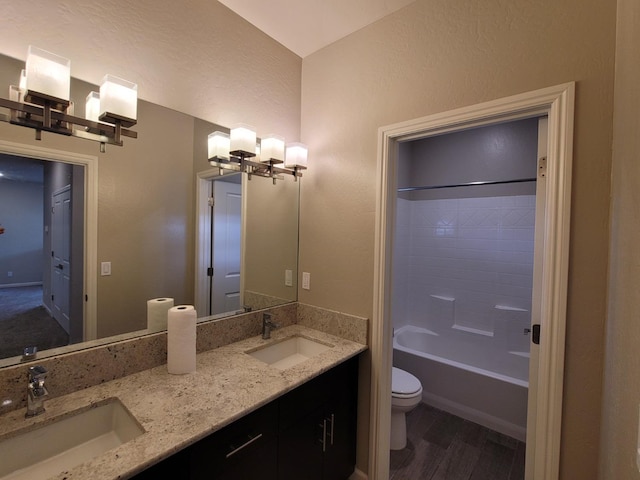 full bathroom featuring double vanity, a sink, wood finished floors, and toilet
