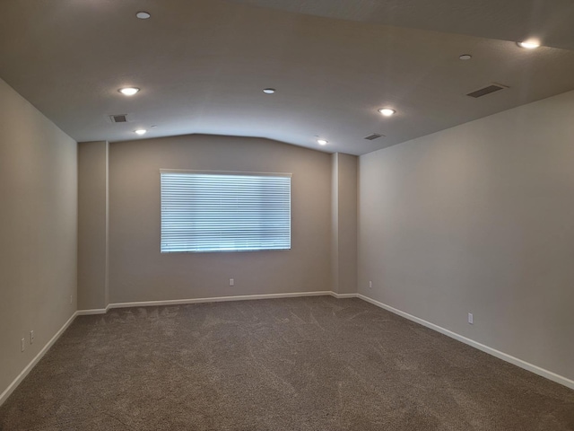 unfurnished room with visible vents, baseboards, dark colored carpet, lofted ceiling, and recessed lighting