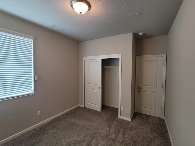 unfurnished bedroom featuring a closet, baseboards, carpet flooring, and visible vents