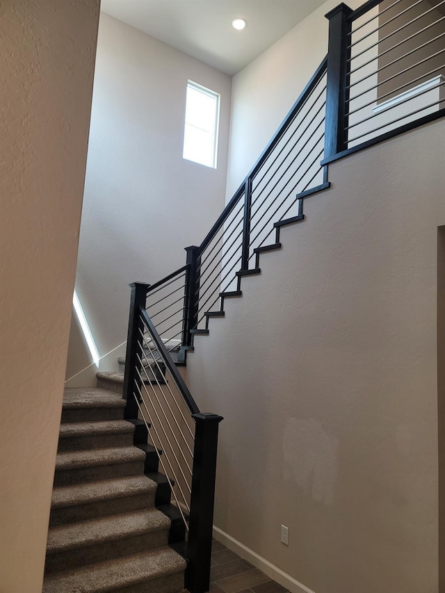 stairway with recessed lighting, baseboards, and wood finished floors