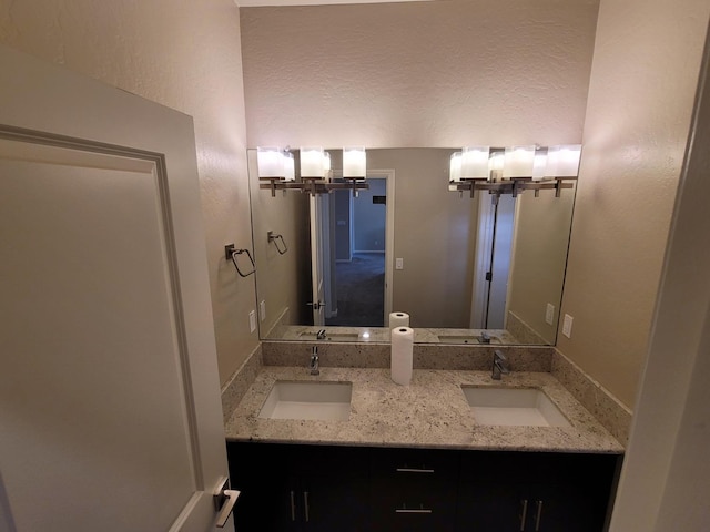 bathroom featuring a sink, a textured ceiling, and a notable chandelier