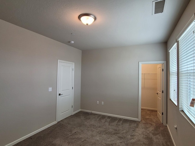 carpeted empty room with visible vents and baseboards