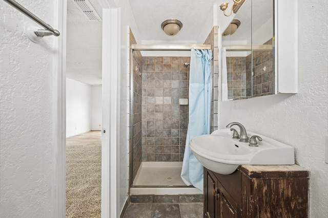 4462 N Manila Ave, Fresno, CA 93727 - bathroom with a textured wall, a stall shower, and vanity