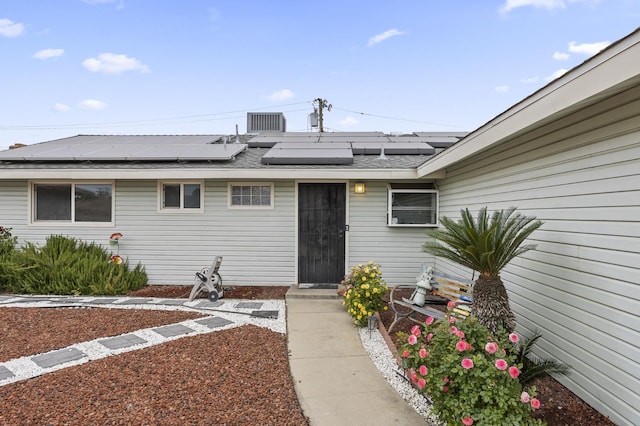 4462 N Manila Ave, Fresno, CA 93727 - view of exterior entry with solar panels and a shingled roof