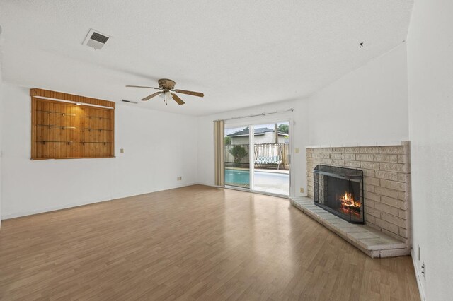 4462 N Manila Ave, Fresno, CA 93727 - unfurnished living room with a brick fireplace, wood finished floors, and ceiling fan