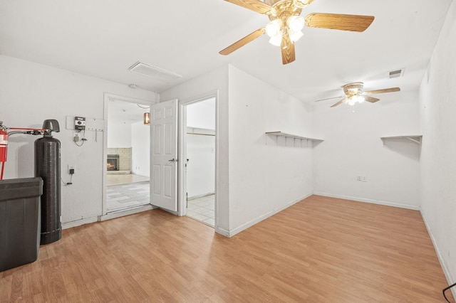 4462 N Manila Ave, Fresno, CA 93727 - empty room with wood finished floors, a ceiling fan, and a warm lit fireplace