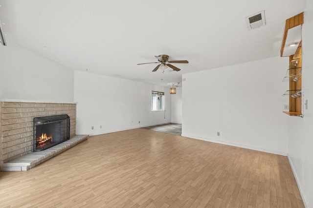 4462 N Manila Ave, Fresno, CA 93727 - unfurnished living room with ceiling fan, a fireplace, and wood finished floors