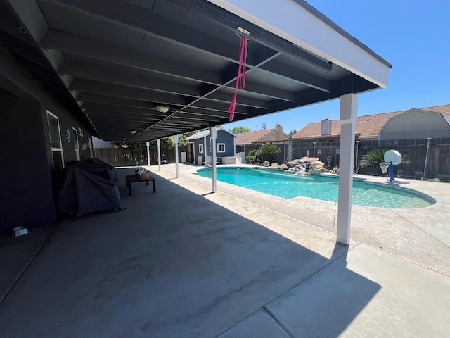 348 E Northridge, Dinuba, CA 93618 - view of swimming pool featuring area for grilling, an outdoor structure, a shed, a fenced backyard, and a patio