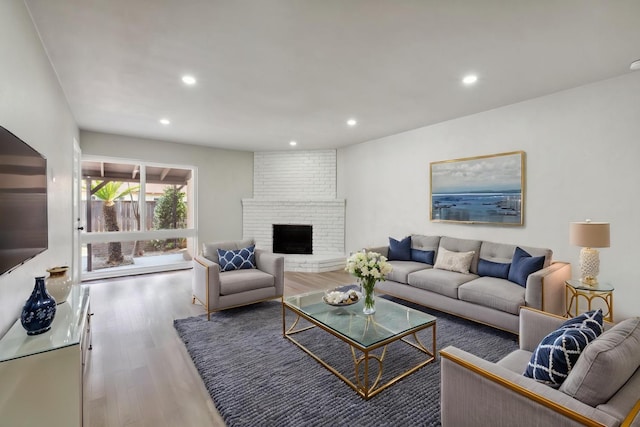 living area featuring recessed lighting, wood finished floors, and a fireplace