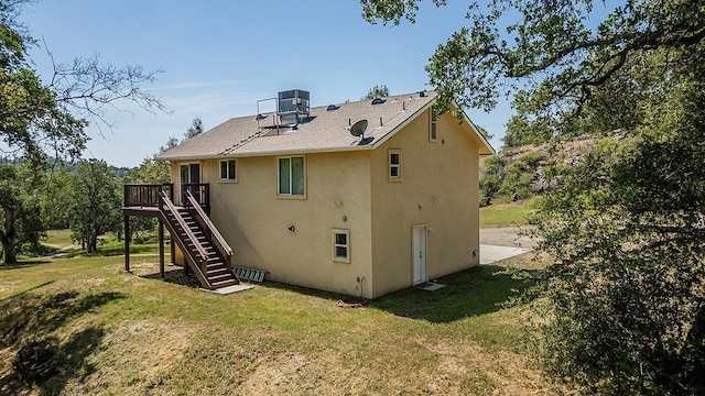 back of house featuring a deck, cooling unit, stucco siding, a yard, and stairway