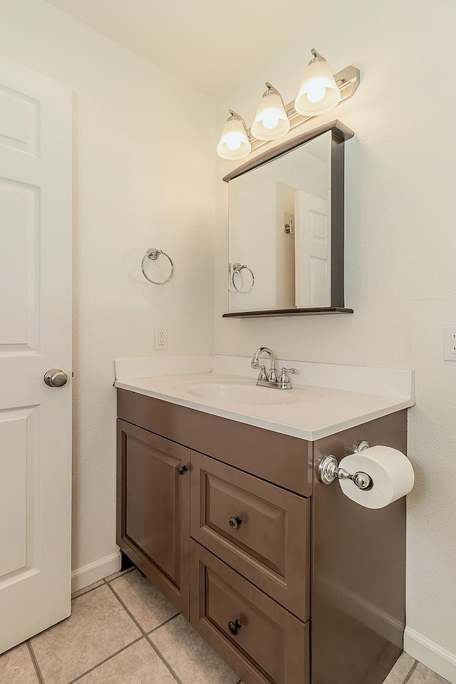 bathroom featuring baseboards, tile patterned flooring, and vanity