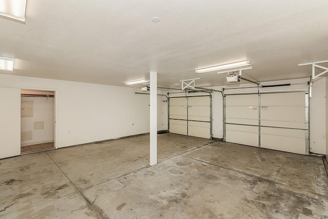 garage with a garage door opener and electric panel