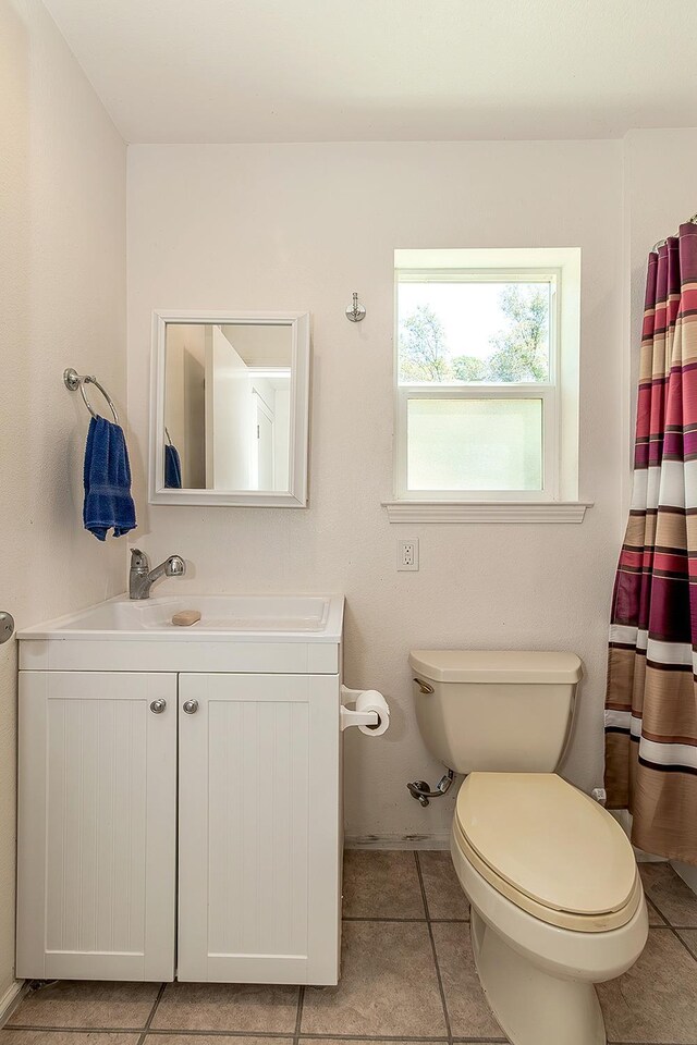 bathroom featuring vanity, tile patterned flooring, and toilet