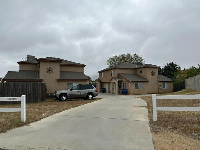 20204 Mini Ct, Tehachapi, CA 93561 - view of front of house featuring concrete driveway, stucco siding, and fence