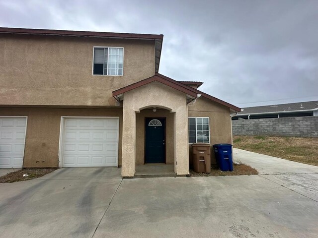20204 Mini Ct, Tehachapi, CA 93561 - view of front of home with fence, a garage, stucco siding, and driveway