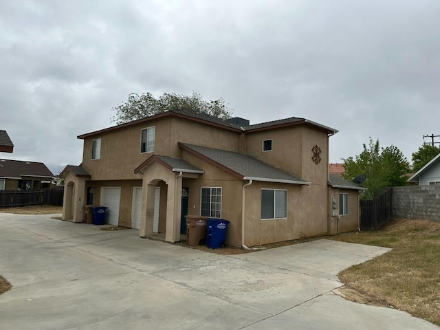 20204 Mini Ct, Tehachapi, CA 93561 - rear view of house featuring stucco siding, driveway, fence, and a garage
