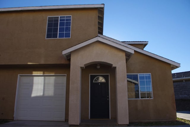view of front facade with a garage and stucco siding