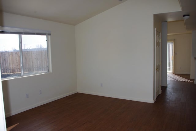 spare room with baseboards and wood finished floors