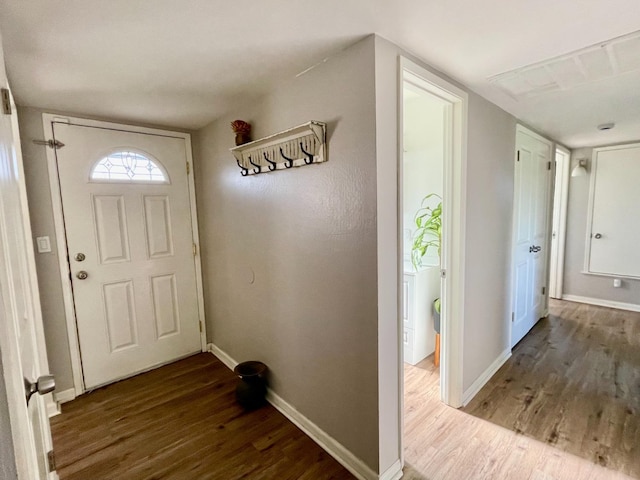 doorway to outside featuring baseboards and wood finished floors