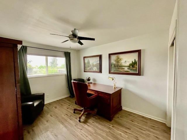 office with baseboards, ceiling fan, and light wood-style flooring