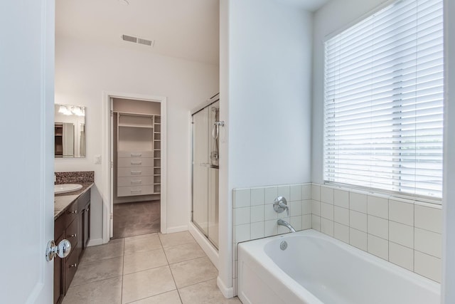 bathroom featuring a walk in closet, visible vents, a stall shower, vanity, and tile patterned floors