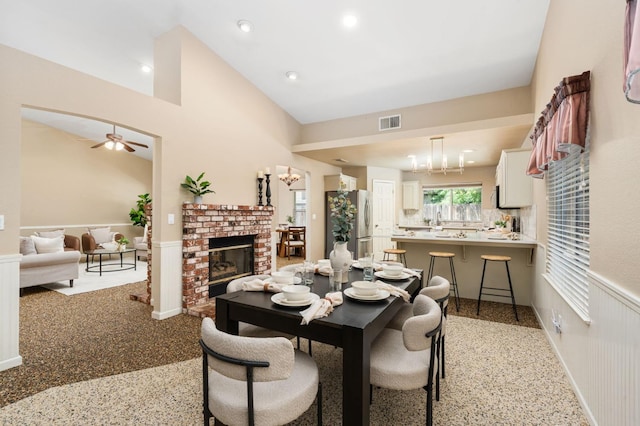 4650 W Chennault Ave, Fresno, CA 93722 - dining space with dark aggregate flooring, a wainscoted wall, a ceiling fan, high vaulted ceiling, and recessed lighting