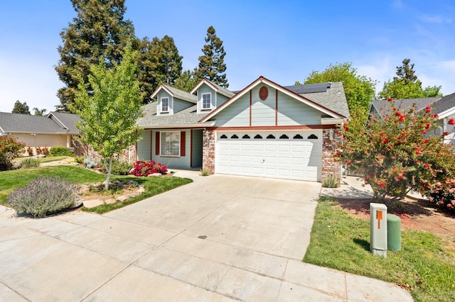 4650 W Chennault Ave, Fresno, CA 93722 - view of front facade with concrete driveway, a garage, roof mounted solar panels, brick siding, and a front lawn