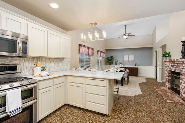 4650 W Chennault Ave, Fresno, CA 93722 - kitchen featuring stainless steel appliances, a peninsula, tasteful backsplash, open floor plan, and ceiling fan