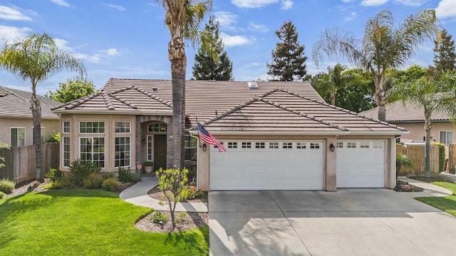 view of front facade featuring fence, an attached garage, concrete driveway, and a tile roof