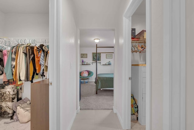 hall with baseboards and light carpet