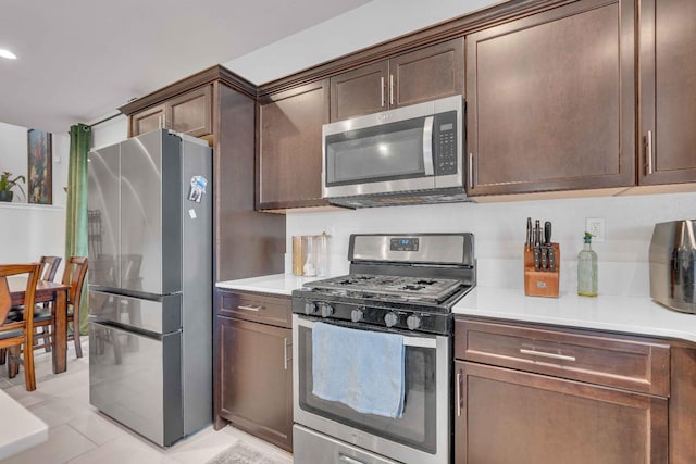 kitchen with light tile patterned flooring, dark brown cabinets, recessed lighting, light countertops, and appliances with stainless steel finishes
