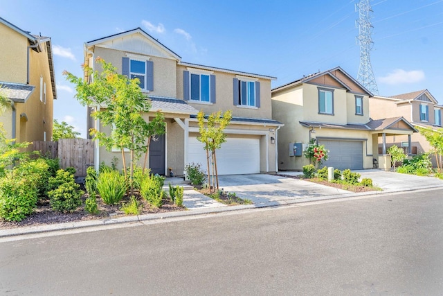 view of front of home featuring a garage, stucco siding, driveway, and fence