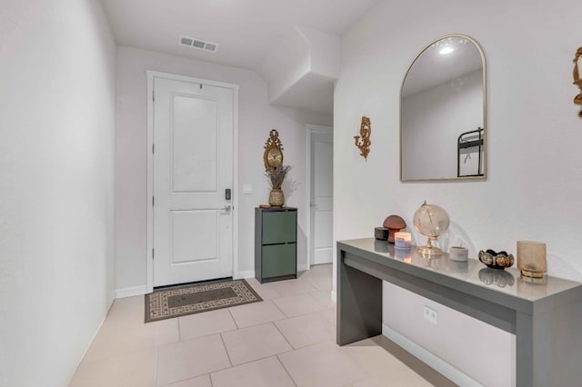 foyer entrance featuring visible vents, baseboards, and light tile patterned floors