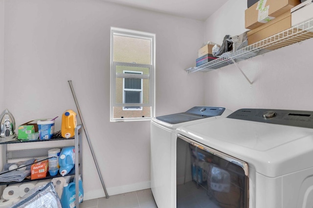 laundry room featuring laundry area, baseboards, light tile patterned floors, and washing machine and clothes dryer