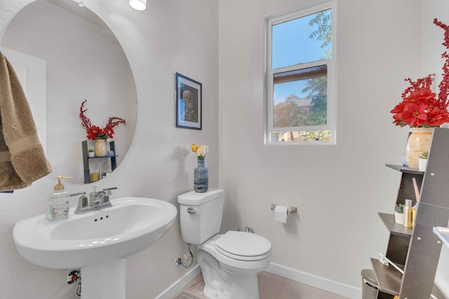 half bath with baseboards and toilet
