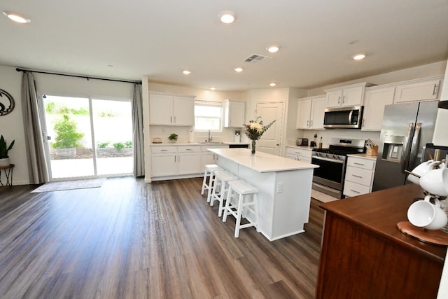1845 George Ave, Sanger, CA 93657 - kitchen featuring appliances with stainless steel finishes, a kitchen island, white cabinetry, a sink, and dark wood-style floors