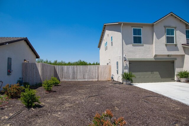 1845 George Ave, Sanger, CA 93657 - view of side of property with fence, an attached garage, driveway, and stucco siding