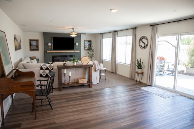 living room featuring ceiling fan, a large fireplace, wood finished floors, baseboards, and recessed lighting
