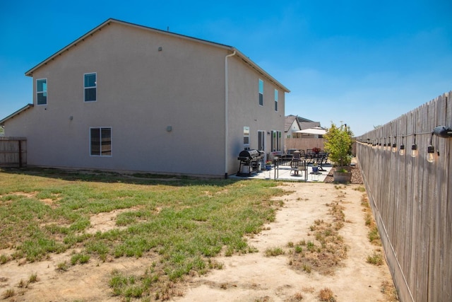view of property exterior featuring a fenced backyard, stucco siding, a lawn, and a patio area