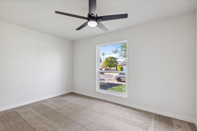 carpeted empty room featuring baseboards and ceiling fan