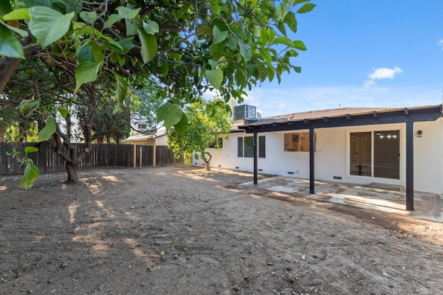 rear view of house with fence, cooling unit, a patio area, and stucco siding