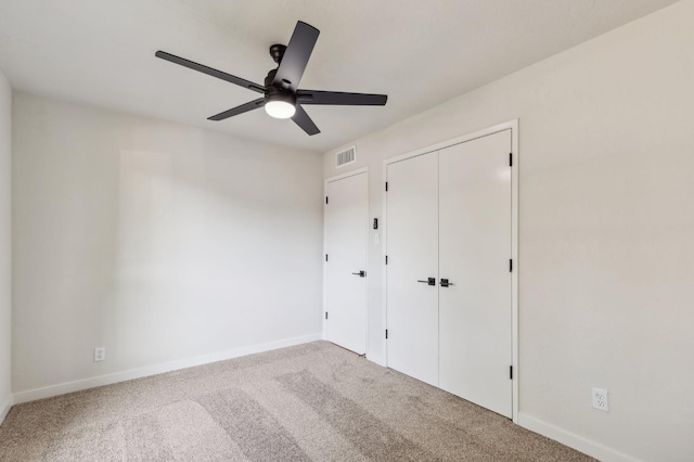unfurnished bedroom with visible vents, carpet flooring, baseboards, and a closet