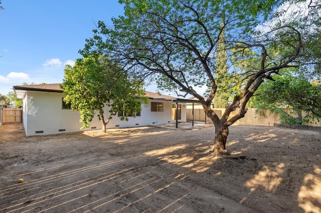 back of property with a fenced backyard and crawl space