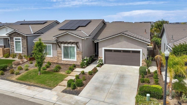 855 Groveland Ave W, Madera, CA 93636 - view of front of property with concrete driveway, solar panels, stone siding, and stucco siding