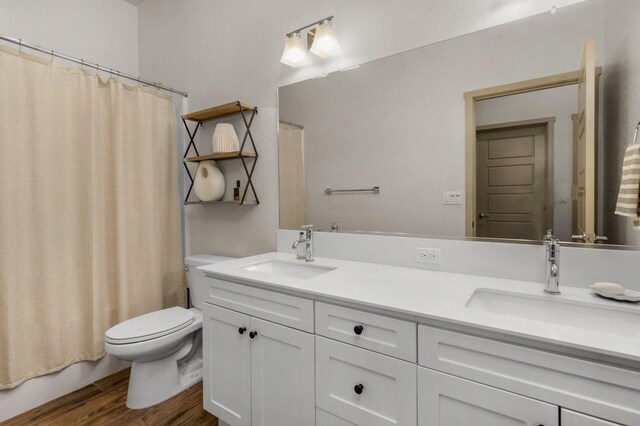 855 Groveland Ave W, Madera, CA 93636 - full bathroom featuring double vanity, a sink, wood finished floors, and toilet